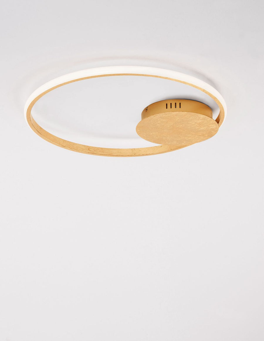 Vue de dessous montrant le diffuseur LED blanc et la rosace dorée