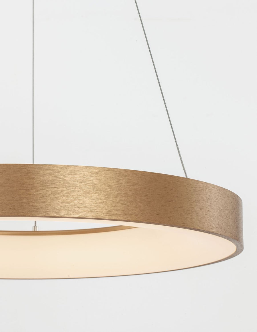 Gros plan sur la finition dorée brossée et le diffuseur blanc du luminaire