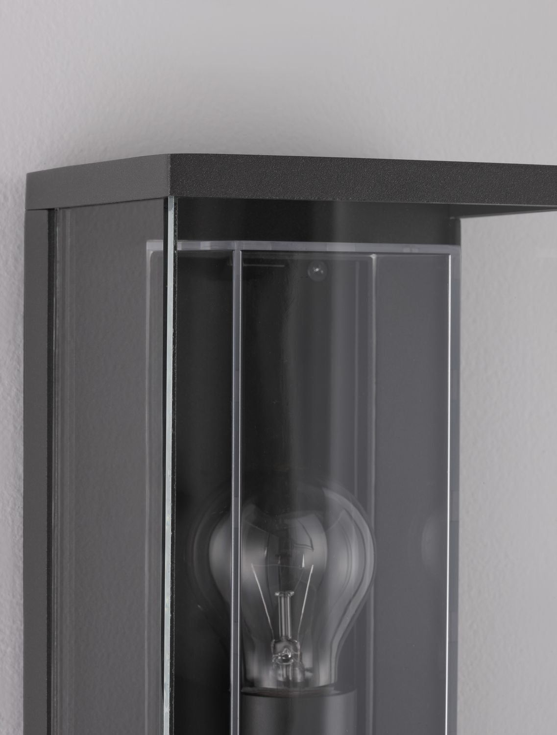 Détail du coin supérieur montrant la finition anthracite grainée et le verre