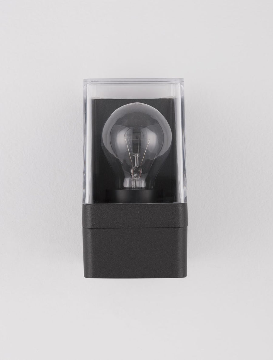 Gros plan frontal, ampoule à filament centrée dans le carré transparent du luminaire