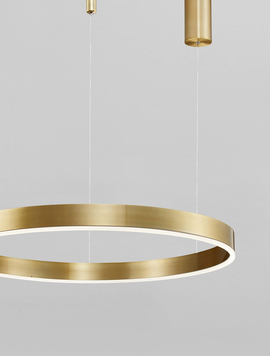 Vue rapprochée du cercle doré et de ses câbles de suspension fins.