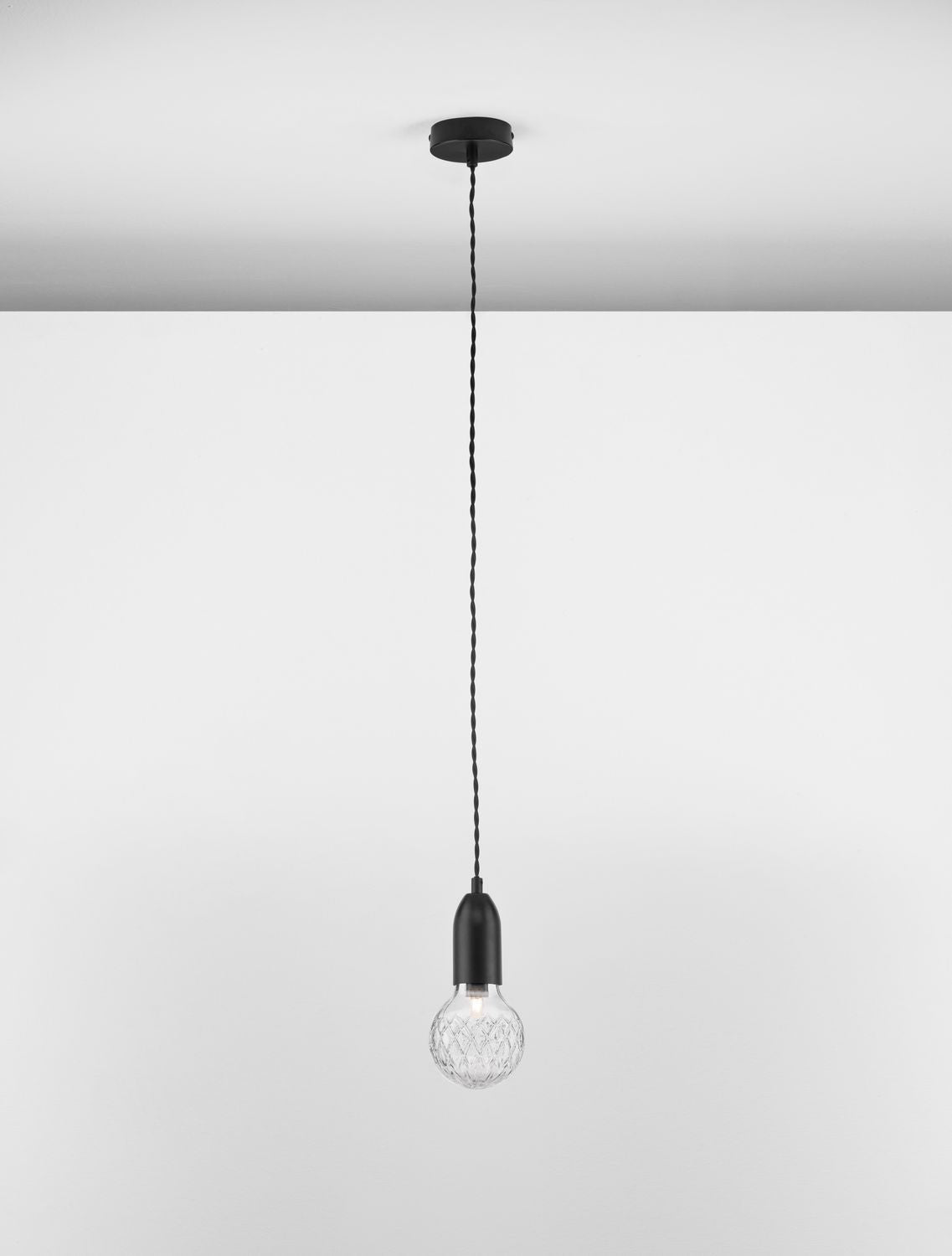 Suspension noire vue de face, câble tressé et ampoule en verre transparente