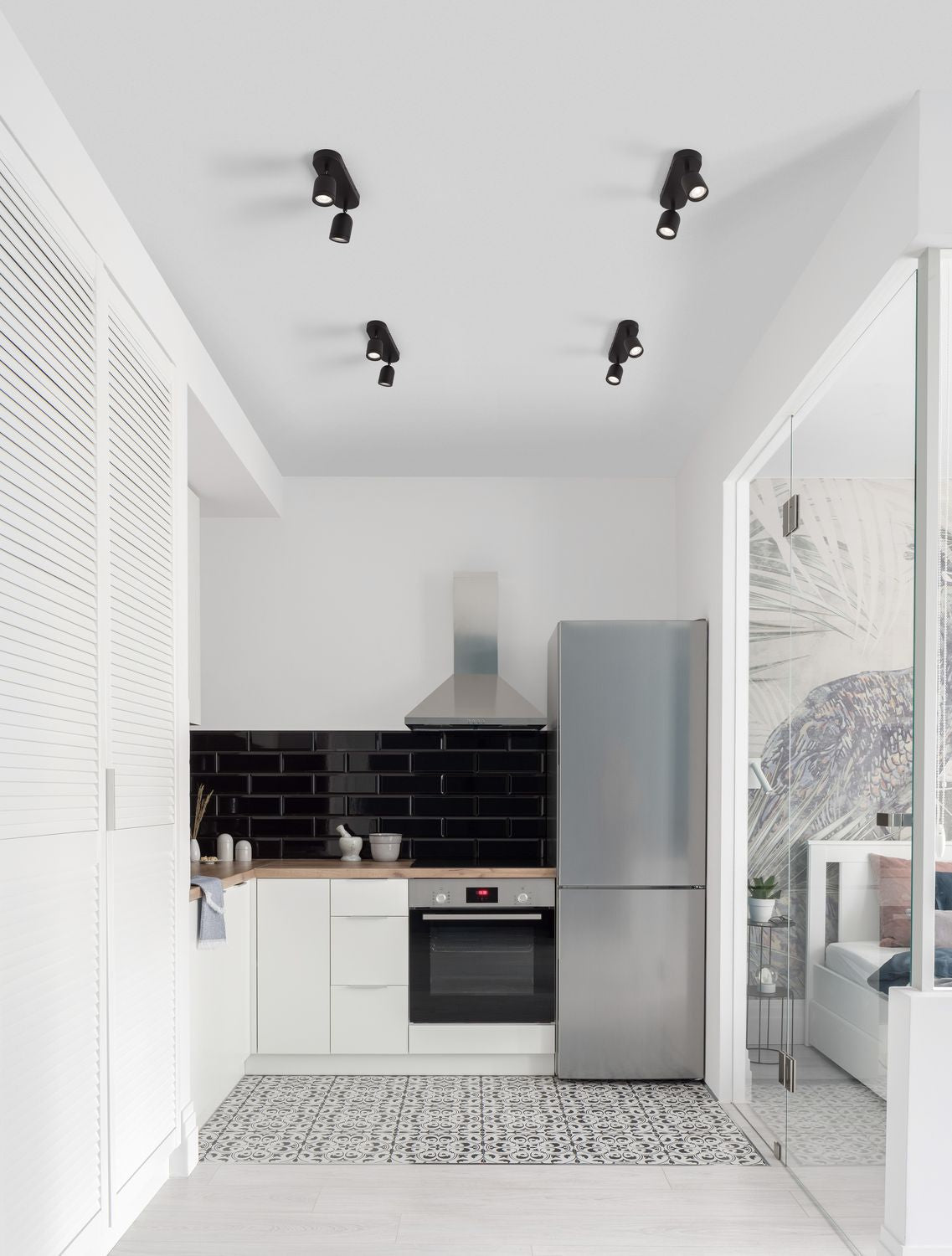 Mise en ambiance d'une cuisine blanche équipée de quatre plafonniers noirs au plafond