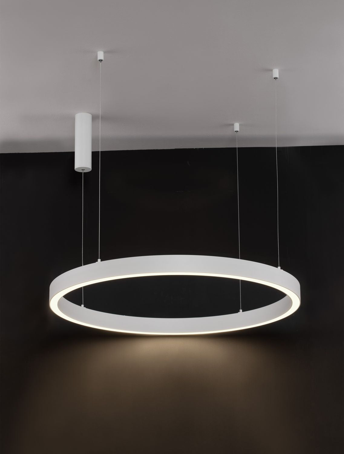 Suspension anneau blanc allumé sur fond sombre, mise en ambiance.