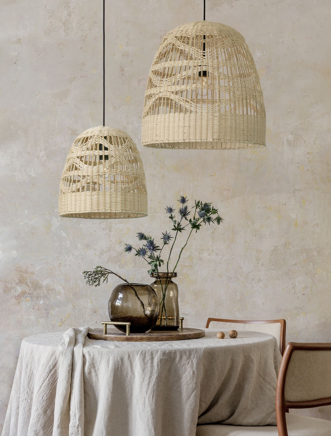 Suspension en rotin beige au-dessus d'une table ronde nappée, mise en ambiance