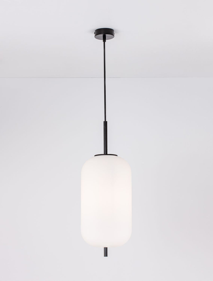 Vue frontale du luminaire allumé, verre opalin et structure métal noir