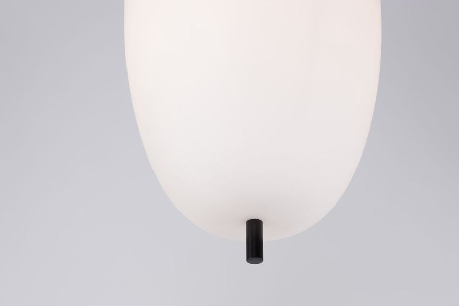 Détail du bas de la suspension avec embout noir sous le verre blanc.