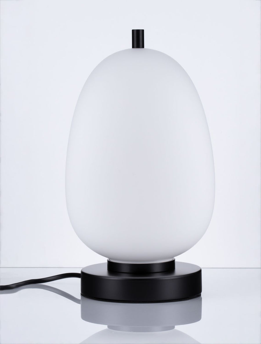 Lampe à poser sur fond gris, câble visible, vue de face détaillée.