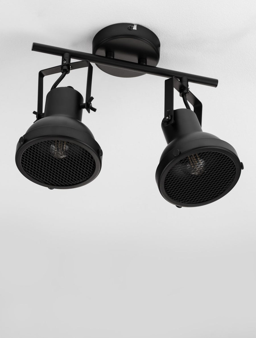 Détail rapproché des deux projecteurs noirs, grille métallique sans ampoule allumée