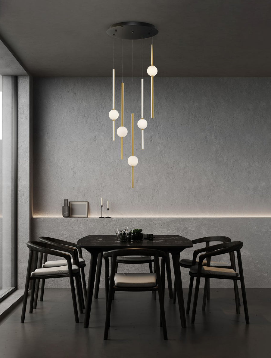 Suspension dorée allumée au-dessus d'une table à manger sombre dans un intérieur béton