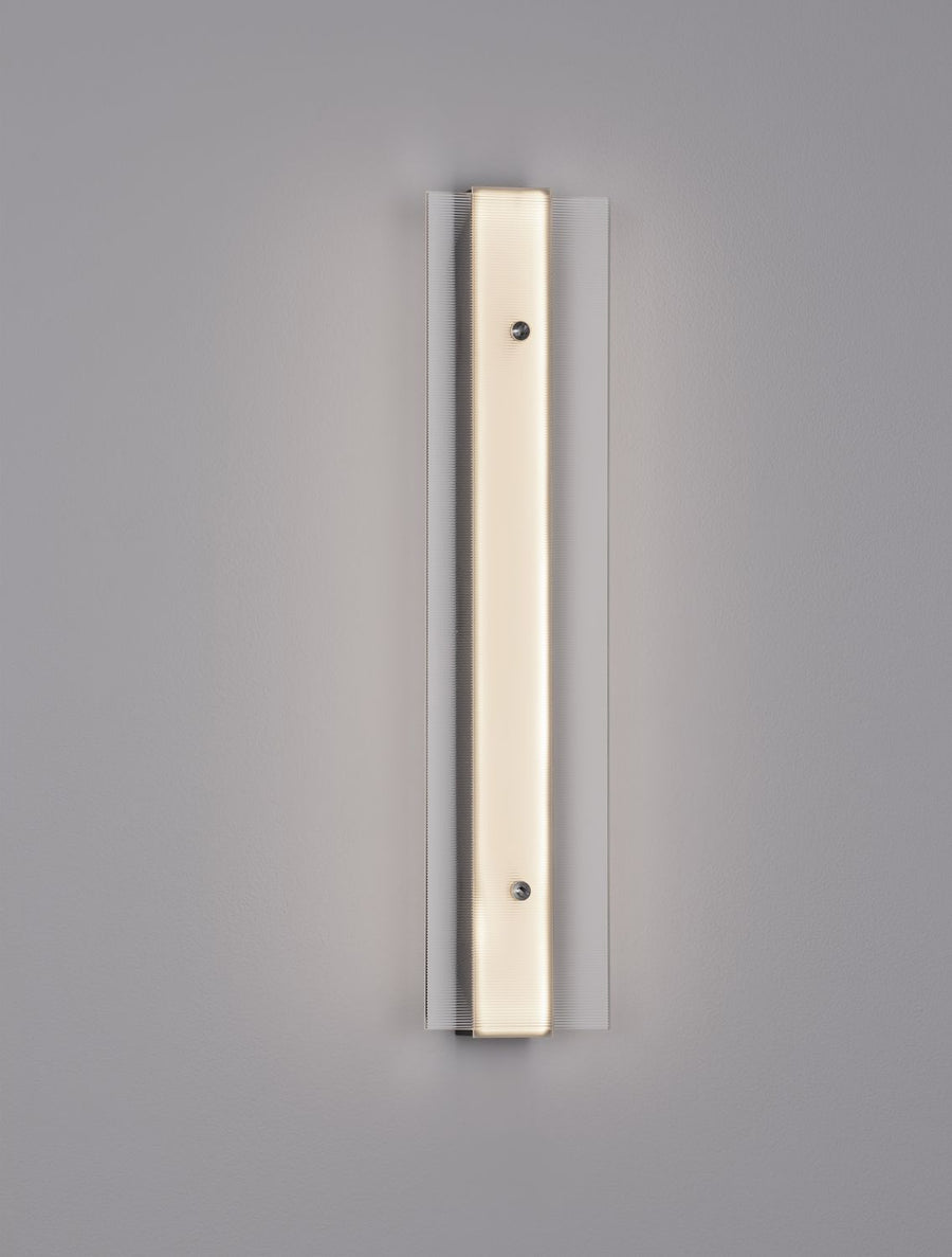 Vue de face de l'applique dorée sur fond gris, verre strié vertical.