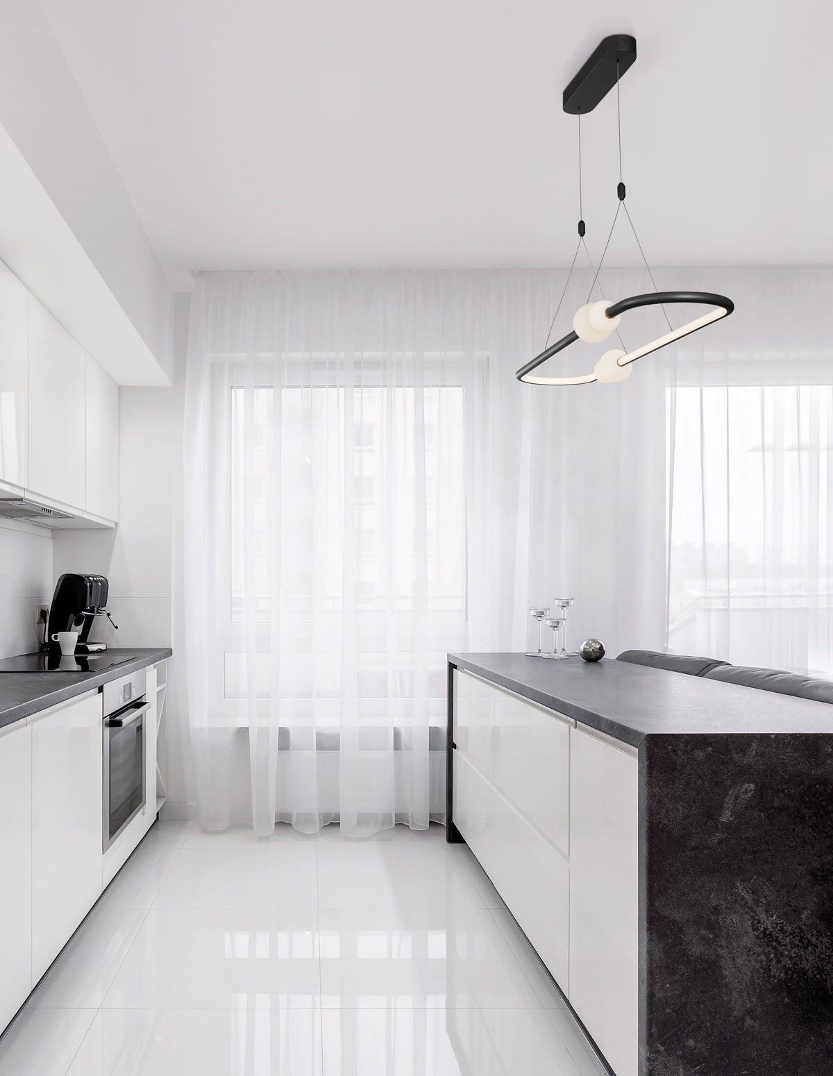 Suspension ovale noire et globes de verre blanc au-dessus d'un îlot de cuisine