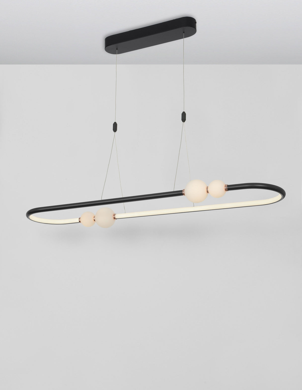 Suspension allumée diffusant une lumière chaude à travers ses globes de verre