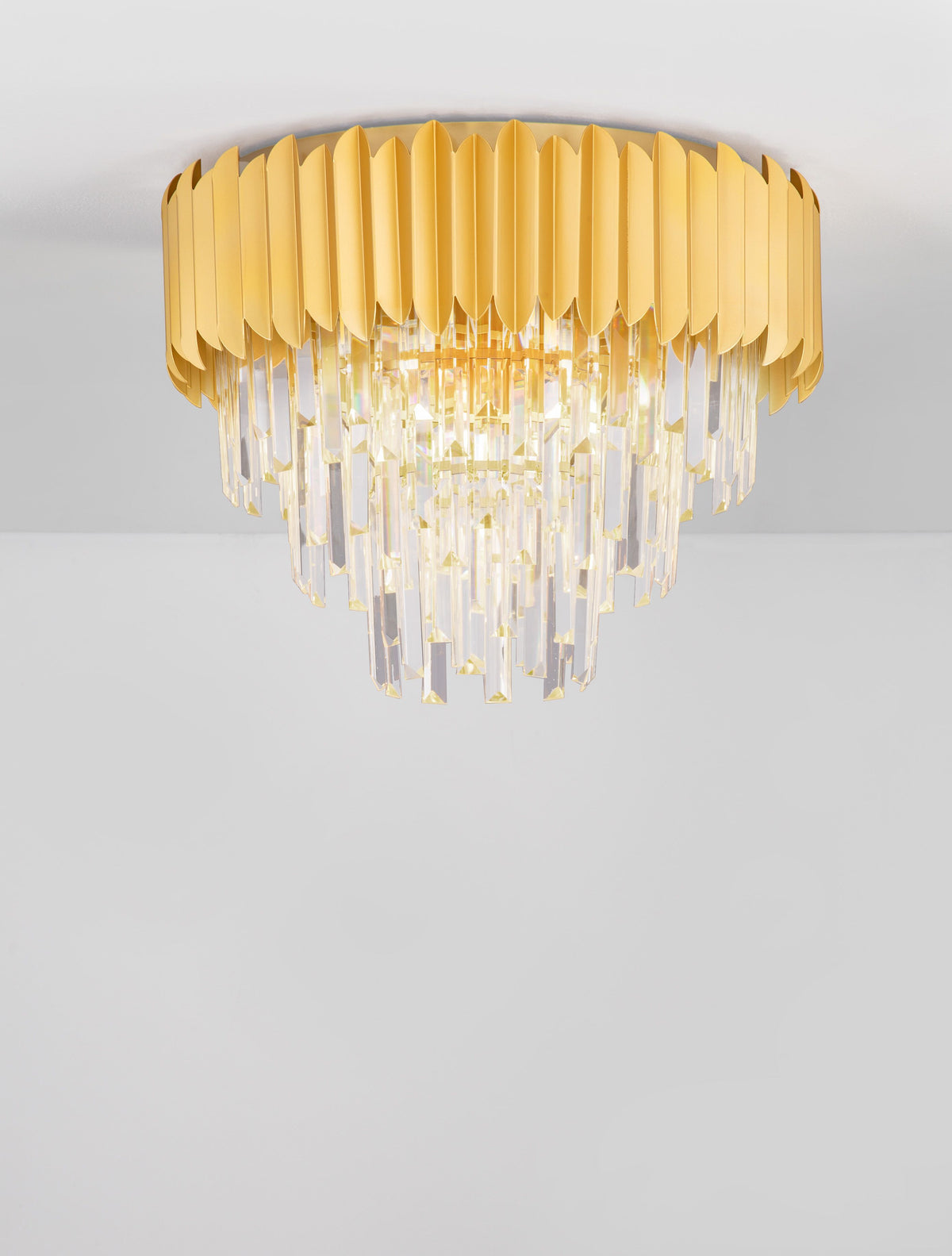 Luminaire doré à pampilles de cristal fixé au plafond, présenté de face