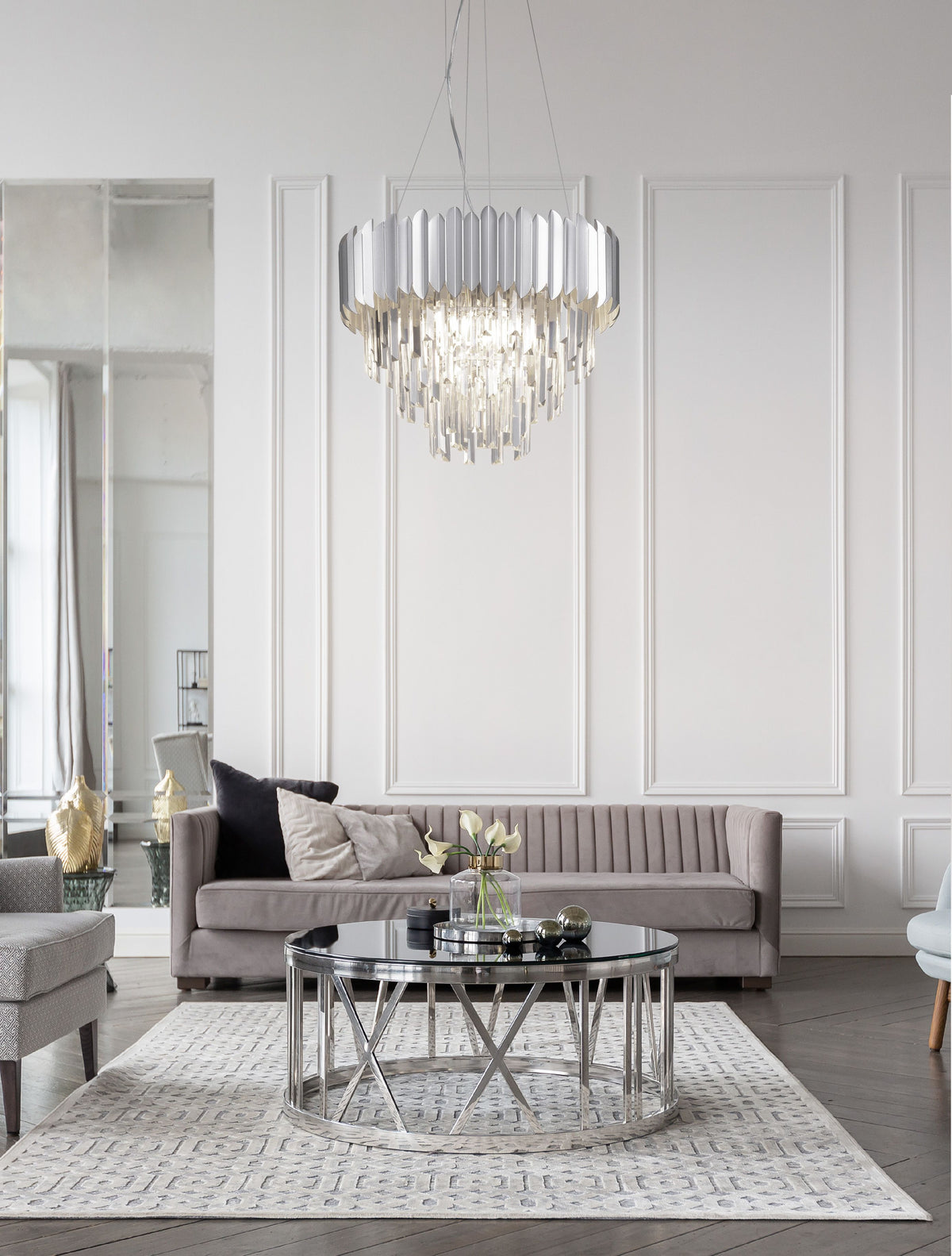 Suspension cristal chromée installée au-dessus d'un salon gris clair contemporain