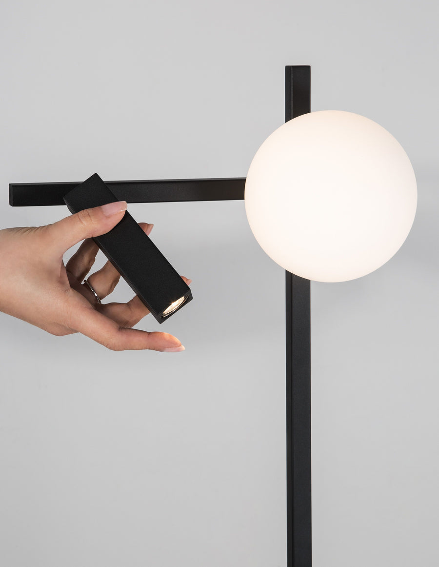 Une main oriente le projecteur du lampadaire pour diriger le faisceau