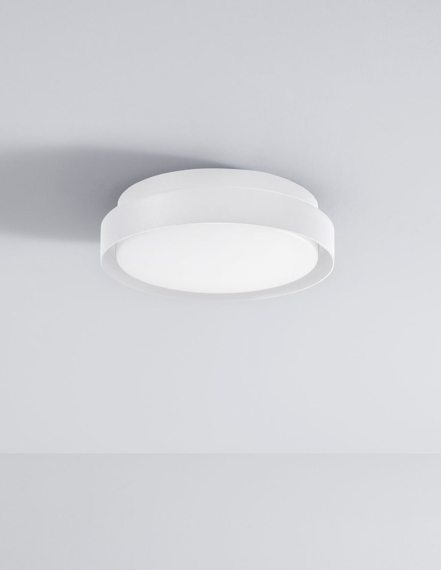 Plafonnier blanc éteint fixé au plafond, anneau métallique et vasque opaline