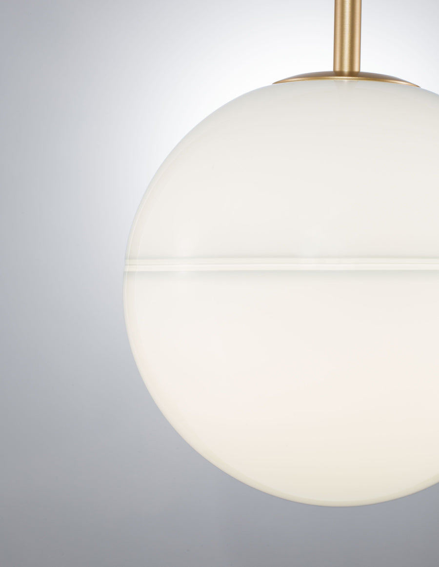 Gros plan sur le globe en verre blanc et la tige dorée
