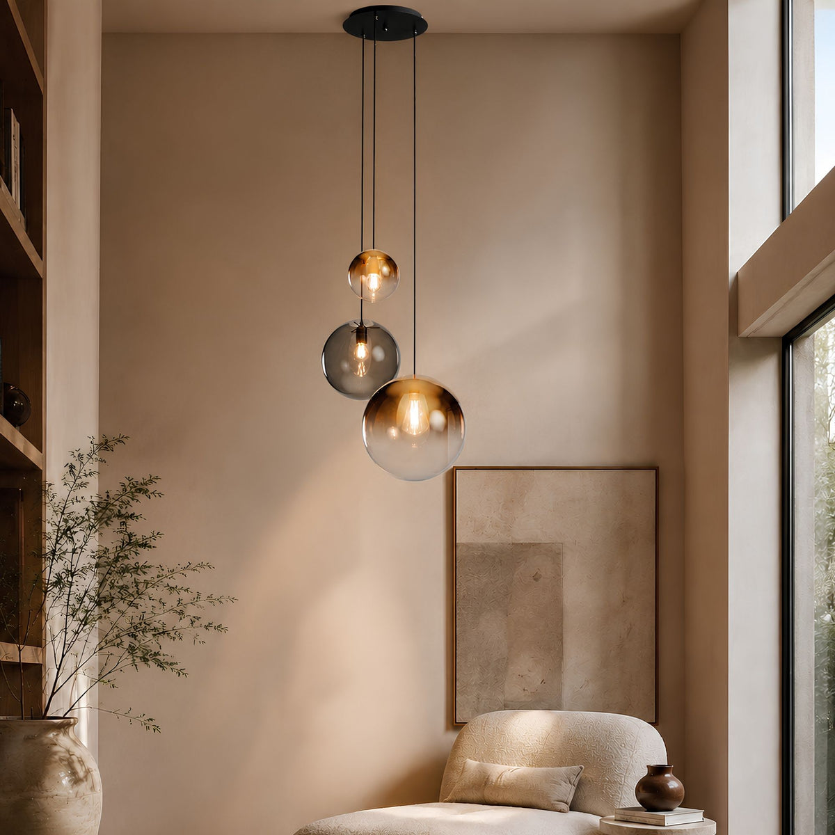 Suspension à trois globes en verre ambré et fumé, câbles noirs, intérieur chaleureux.