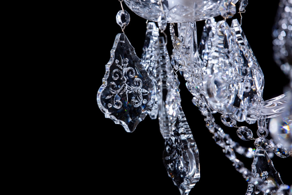 Macro sur les pampilles sculptées et les chaînettes de cristal du luminaire
