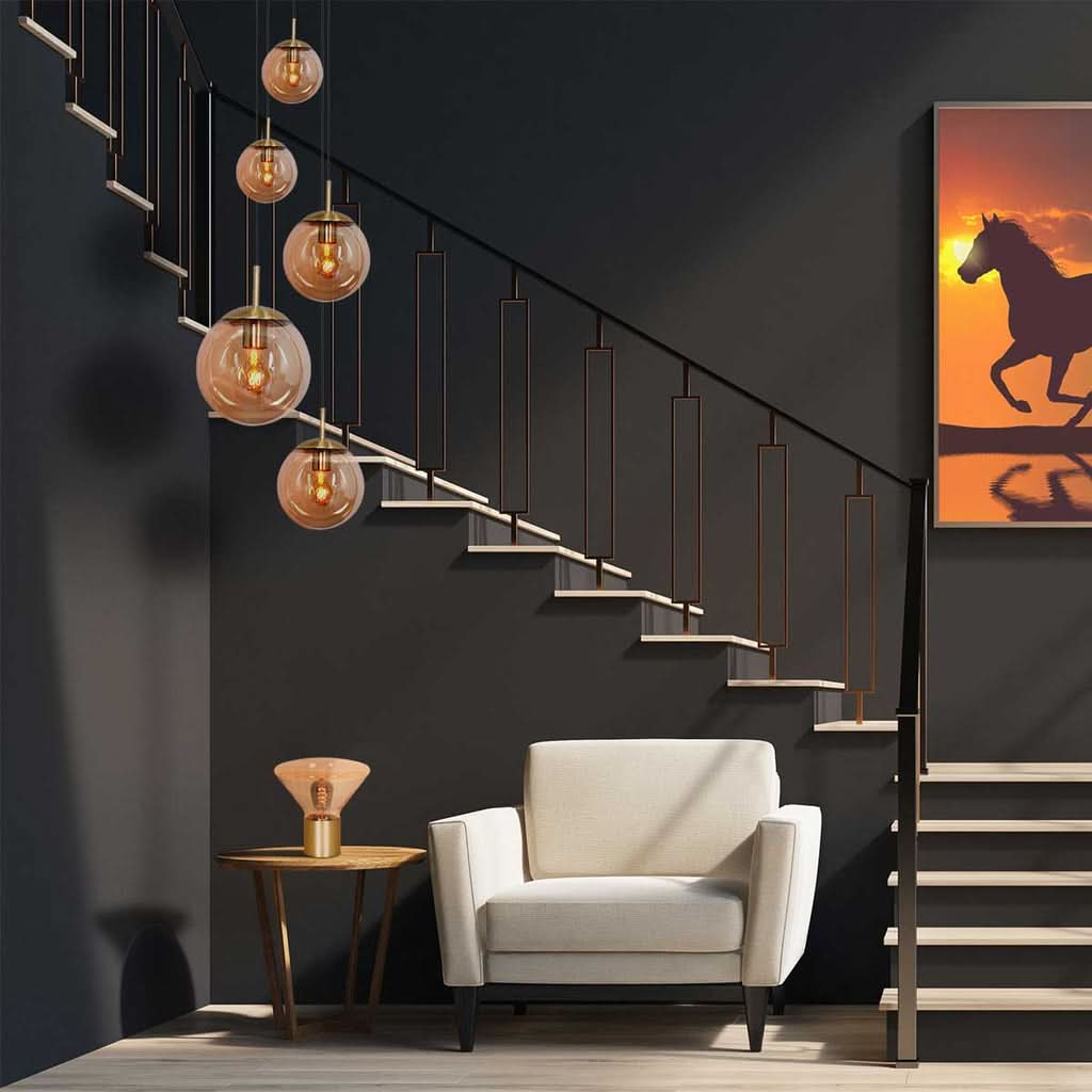 Suspension installée devant un escalier sombre, tableau orange et fauteuil blanc