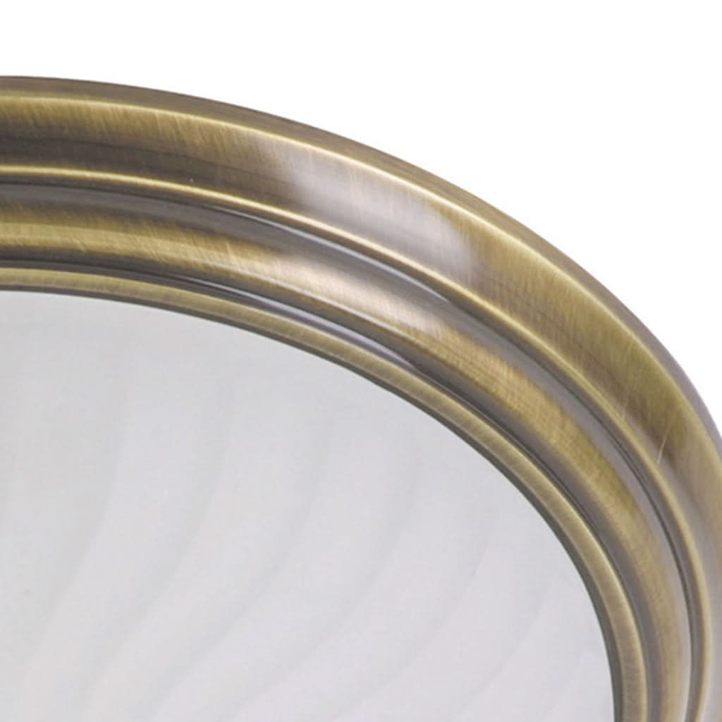Gros plan sur la bague métallique bronze et le verre strié incurvé.