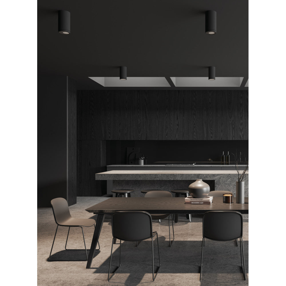 Mise en ambiance : plusieurs plafonniers noirs éclairant une cuisine sombre contemporaine.