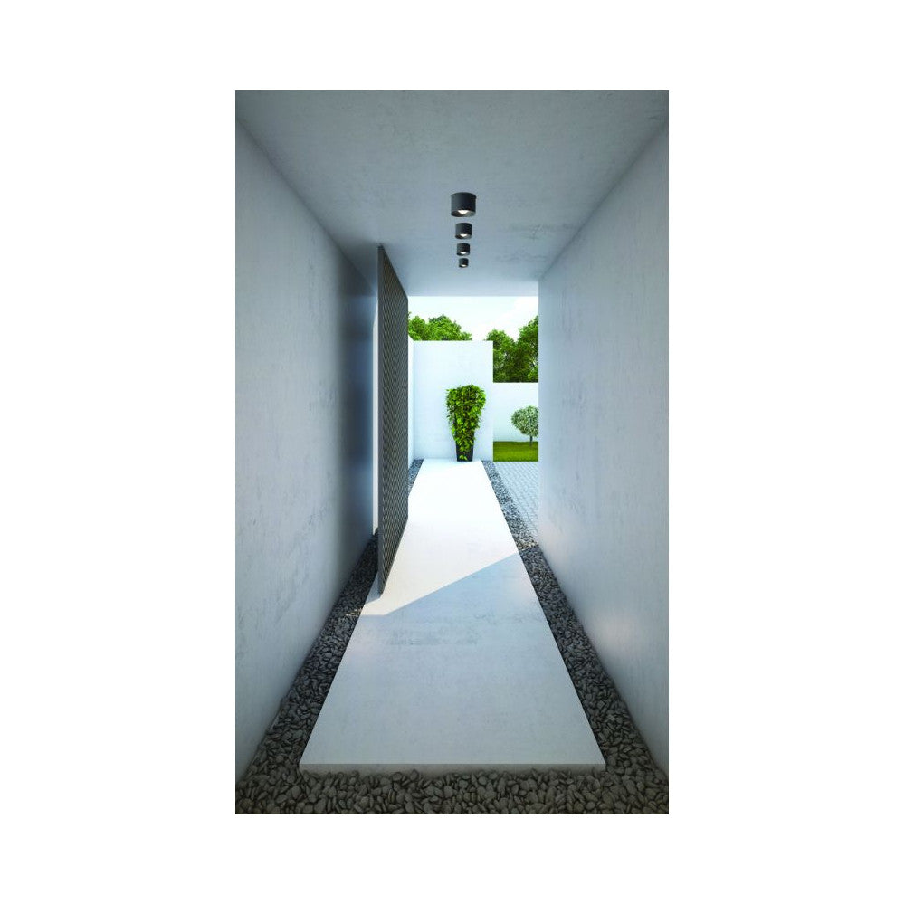 Mise en ambiance dans un couloir blanc avec trois plafonniers alignés