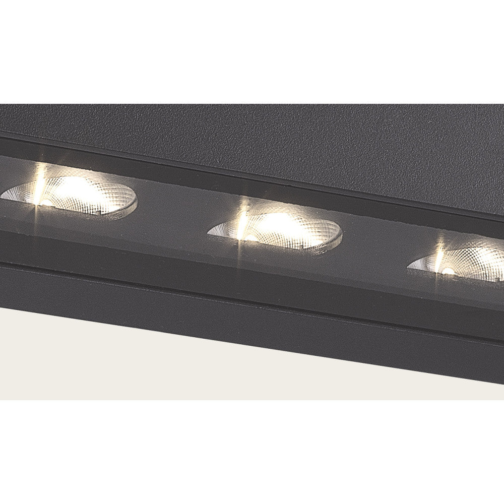 Gros plan sur les trois optiques LED striées et la finition graphite texturée du boîtier