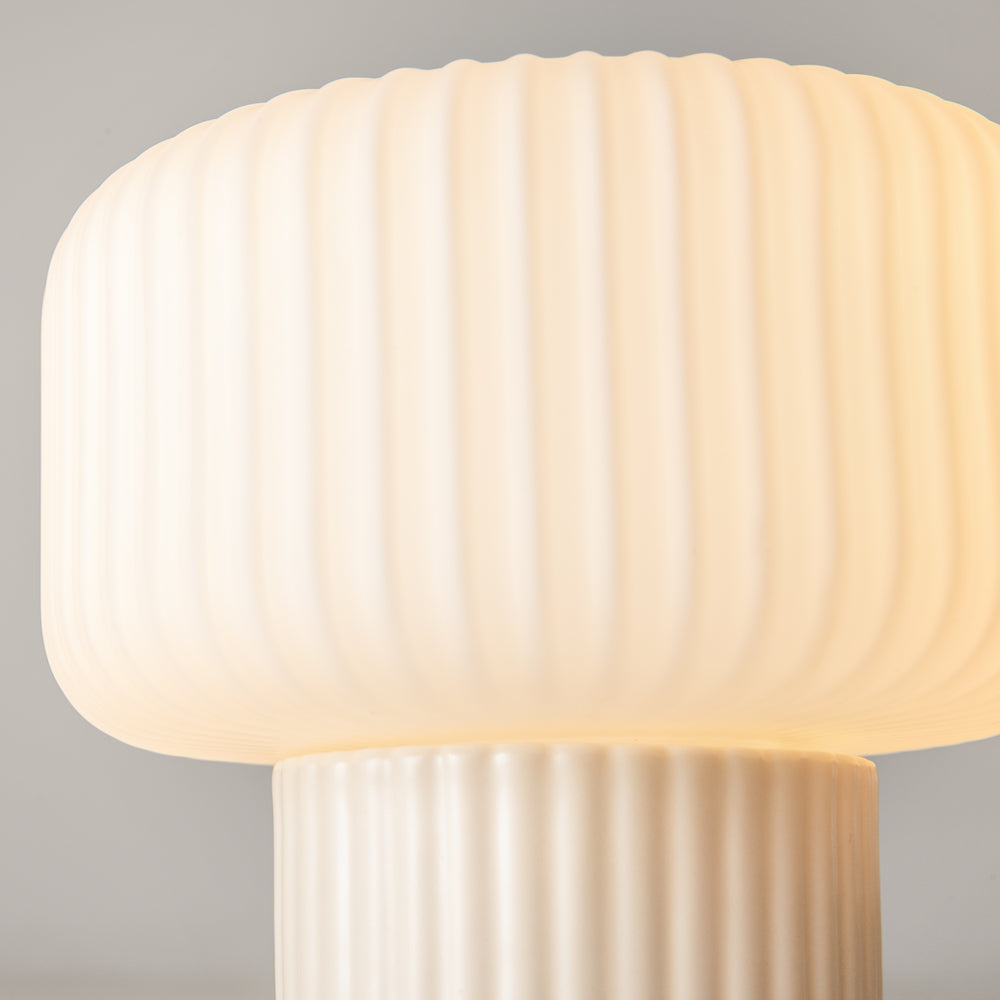 Détail rapproché de l’abat-jour strié, lumière chaude diffusée par la matière translucide.