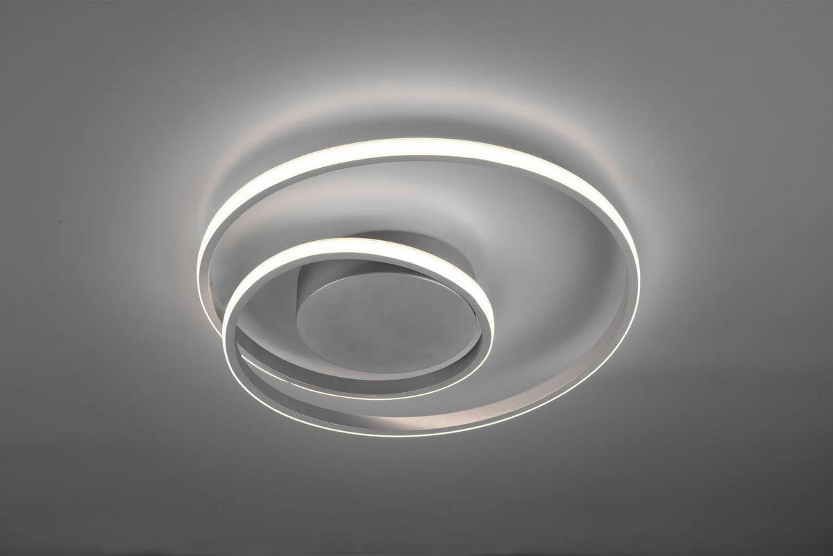 Gros plan du luminaire allumé, anneaux lumineux superposés en lumière blanche