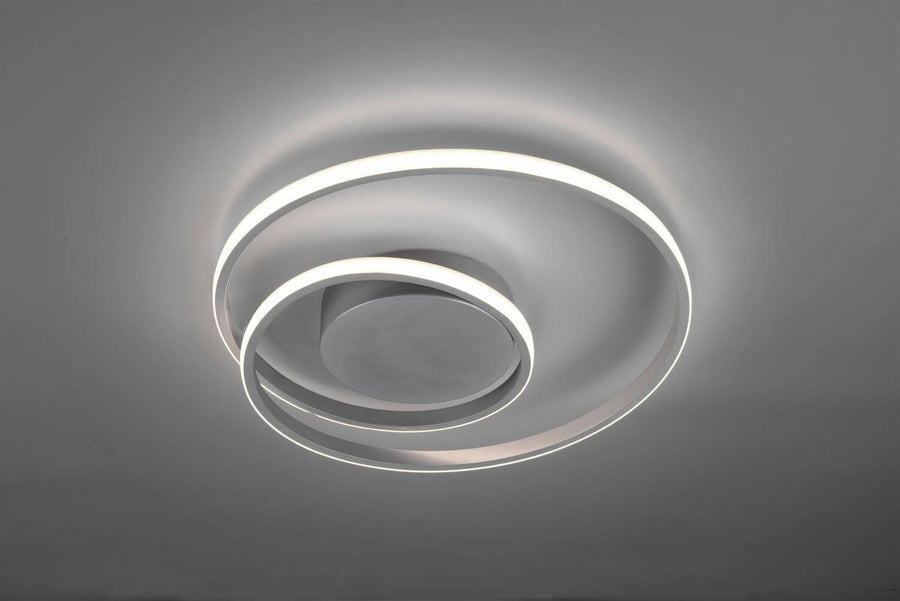 Gros plan du luminaire allumé, anneaux lumineux superposés en lumière blanche