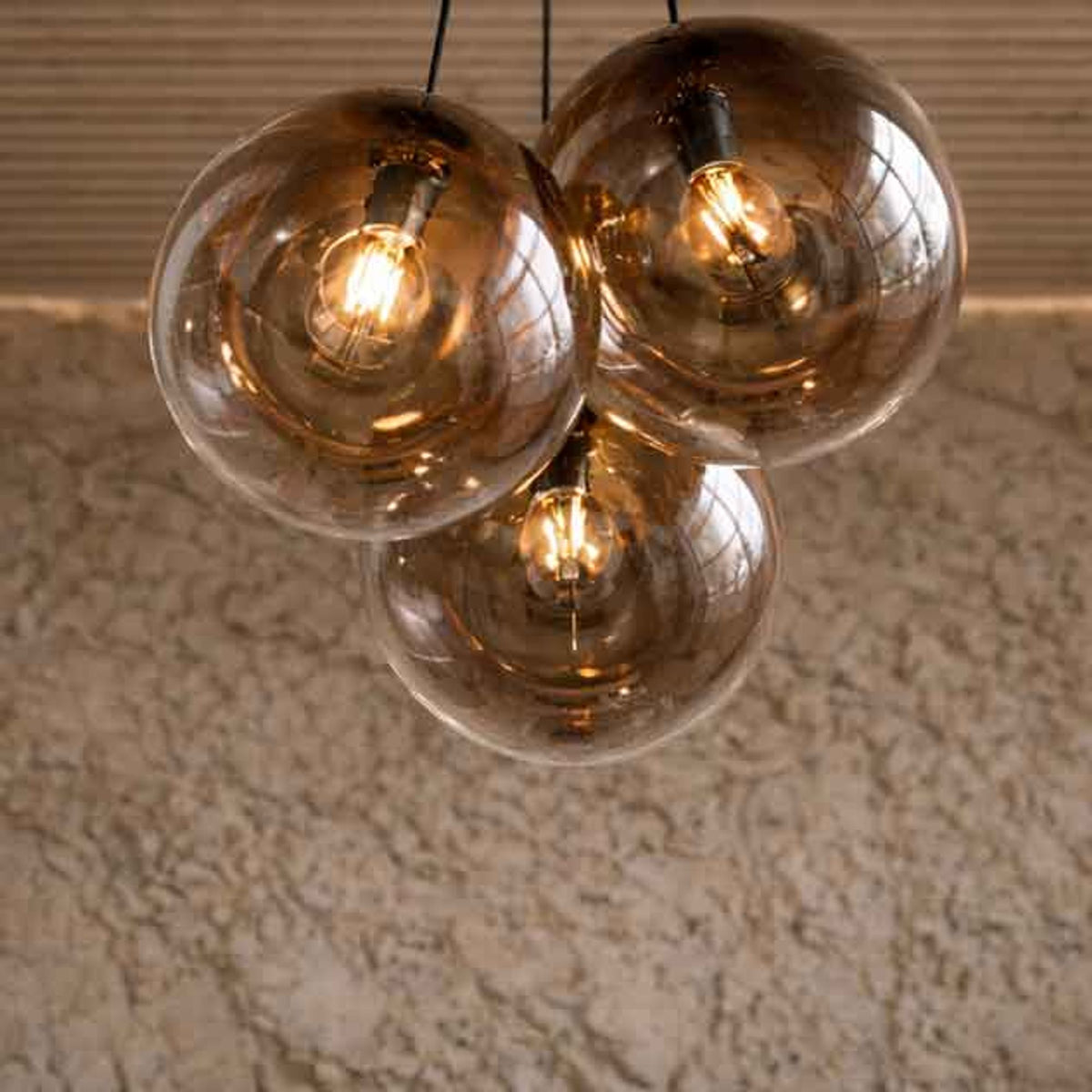 Vue rapprochée des globes en verre fumé ambré suspendus au-dessus du sol