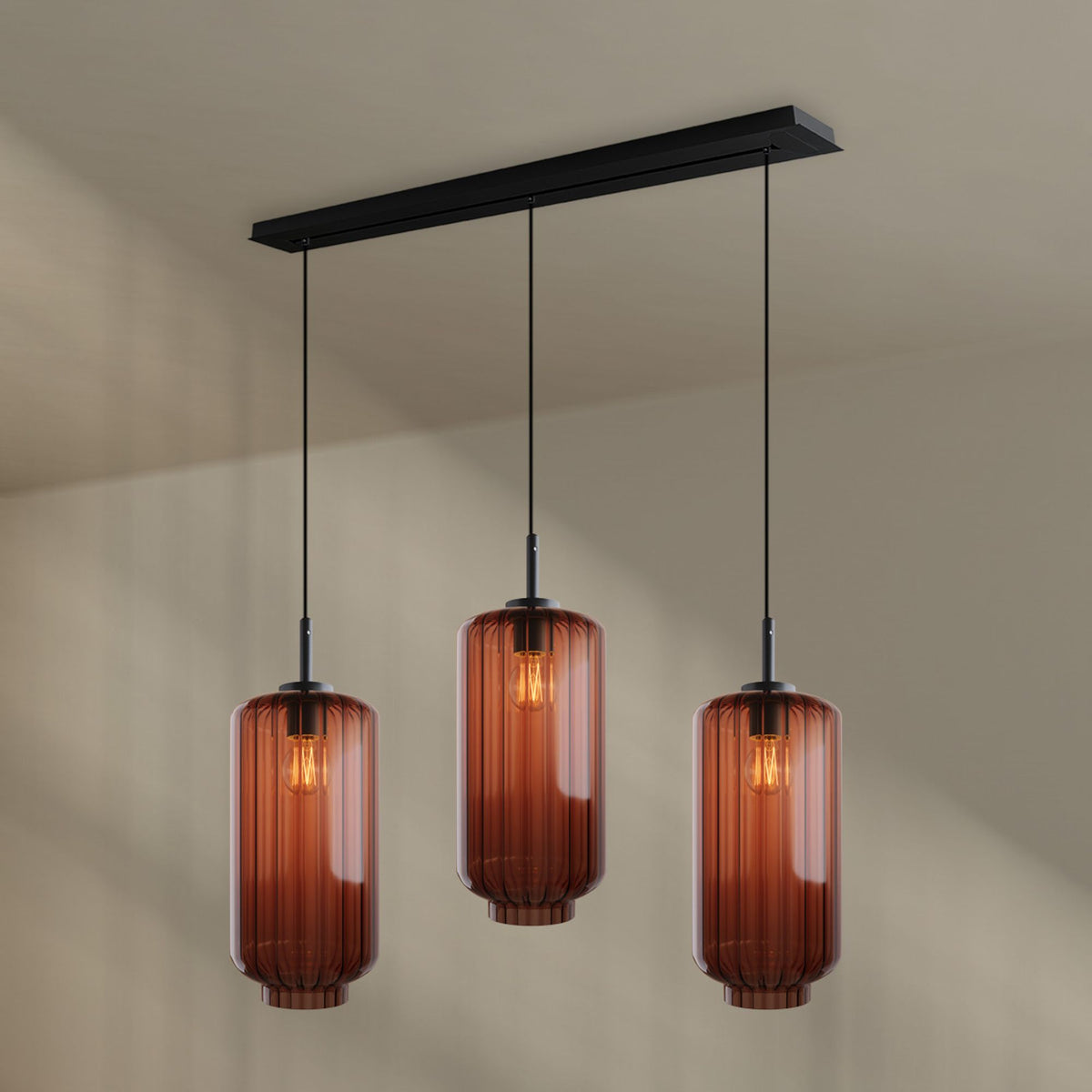 Vue de face, trois globes de verre ambré suspendus à une barre rectangulaire noire
