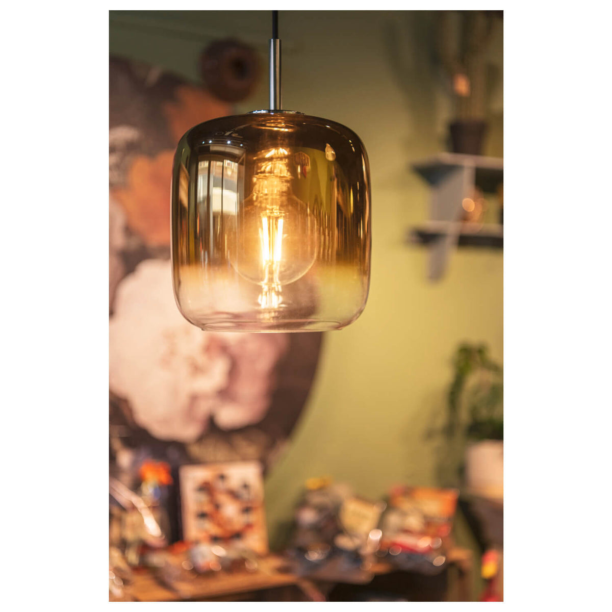 Mise en ambiance chaleureuse de la suspension dorée allumée dans un intérieur décoré.