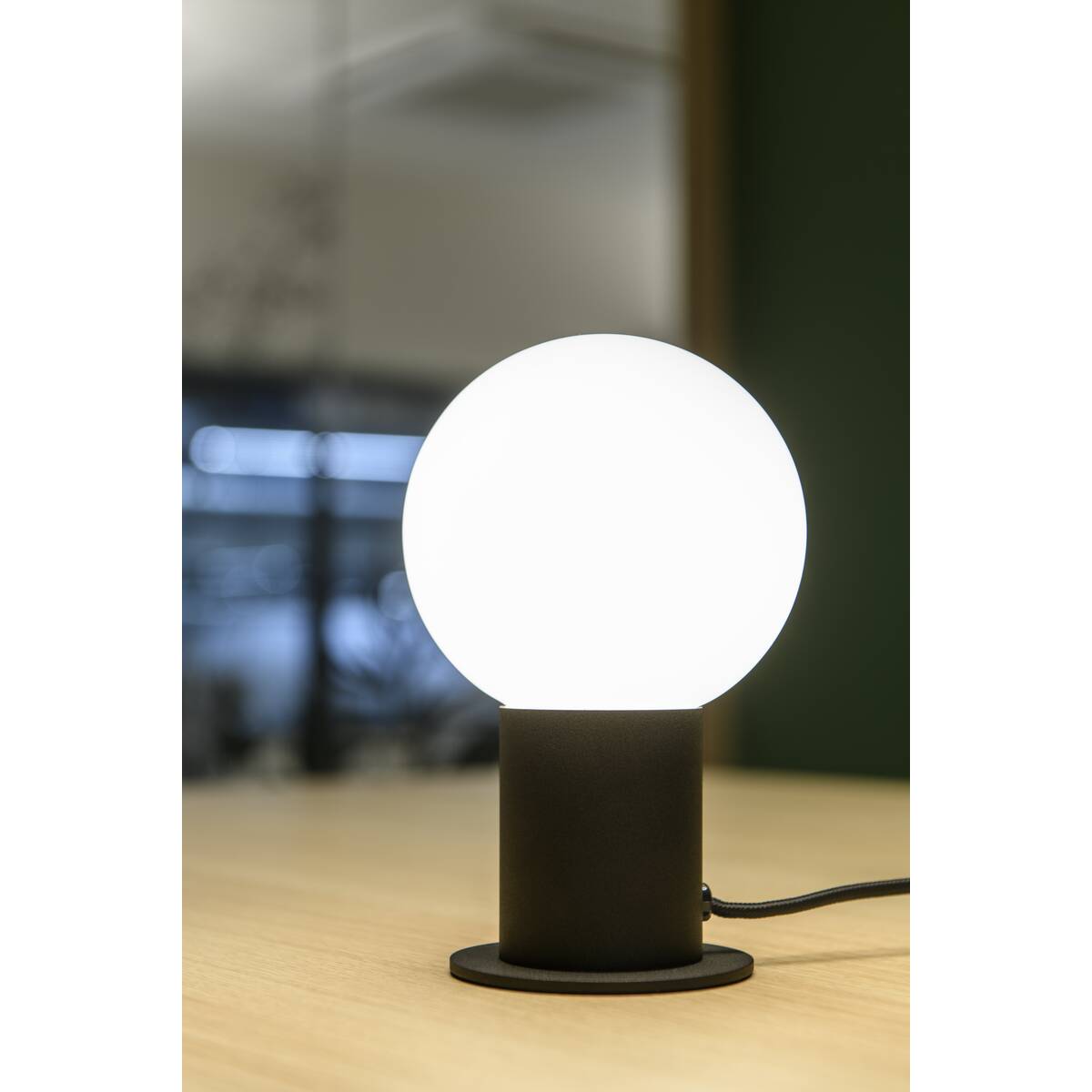 Mise en ambiance sur table en bois, lumière chaude diffusée par le globe