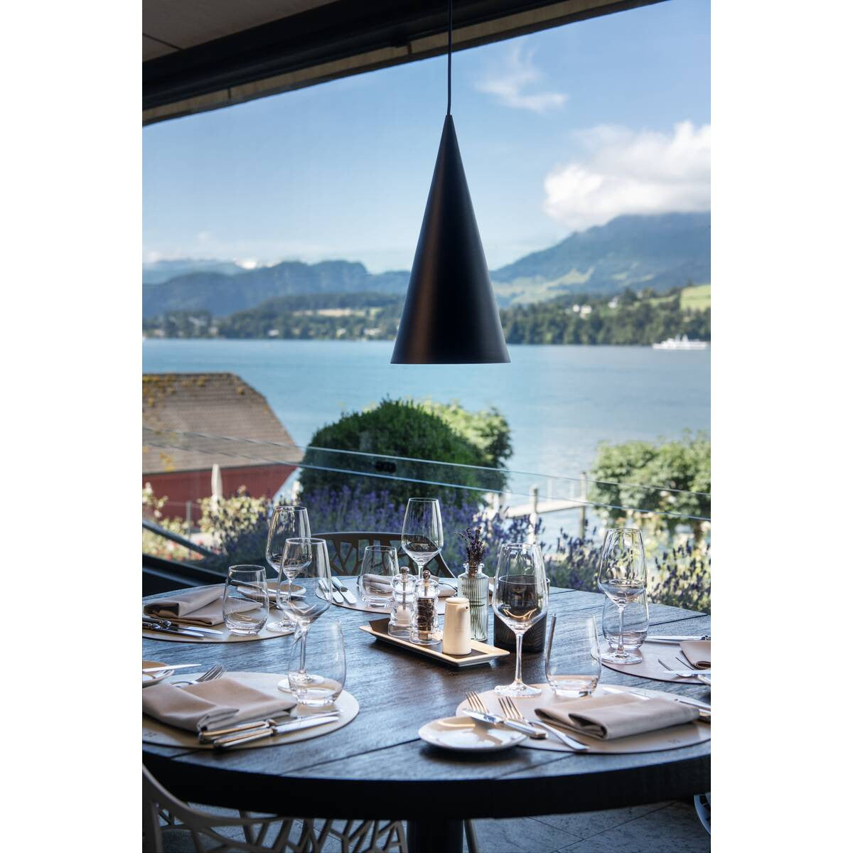 Mise en ambiance au-dessus d'une table dressée face au lac et aux montagnes.