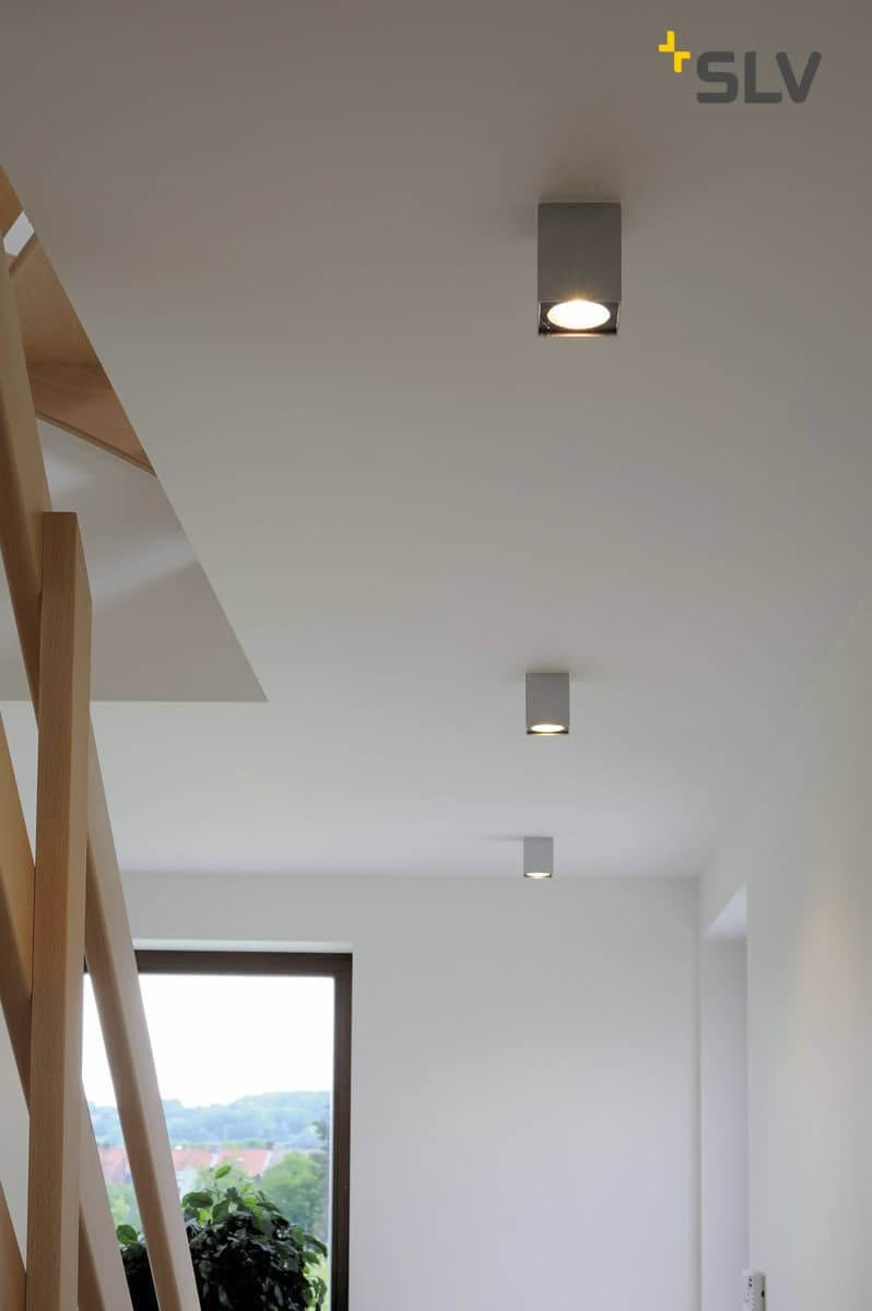 Spots de plafond carrés dans un couloir avec escalier en bois