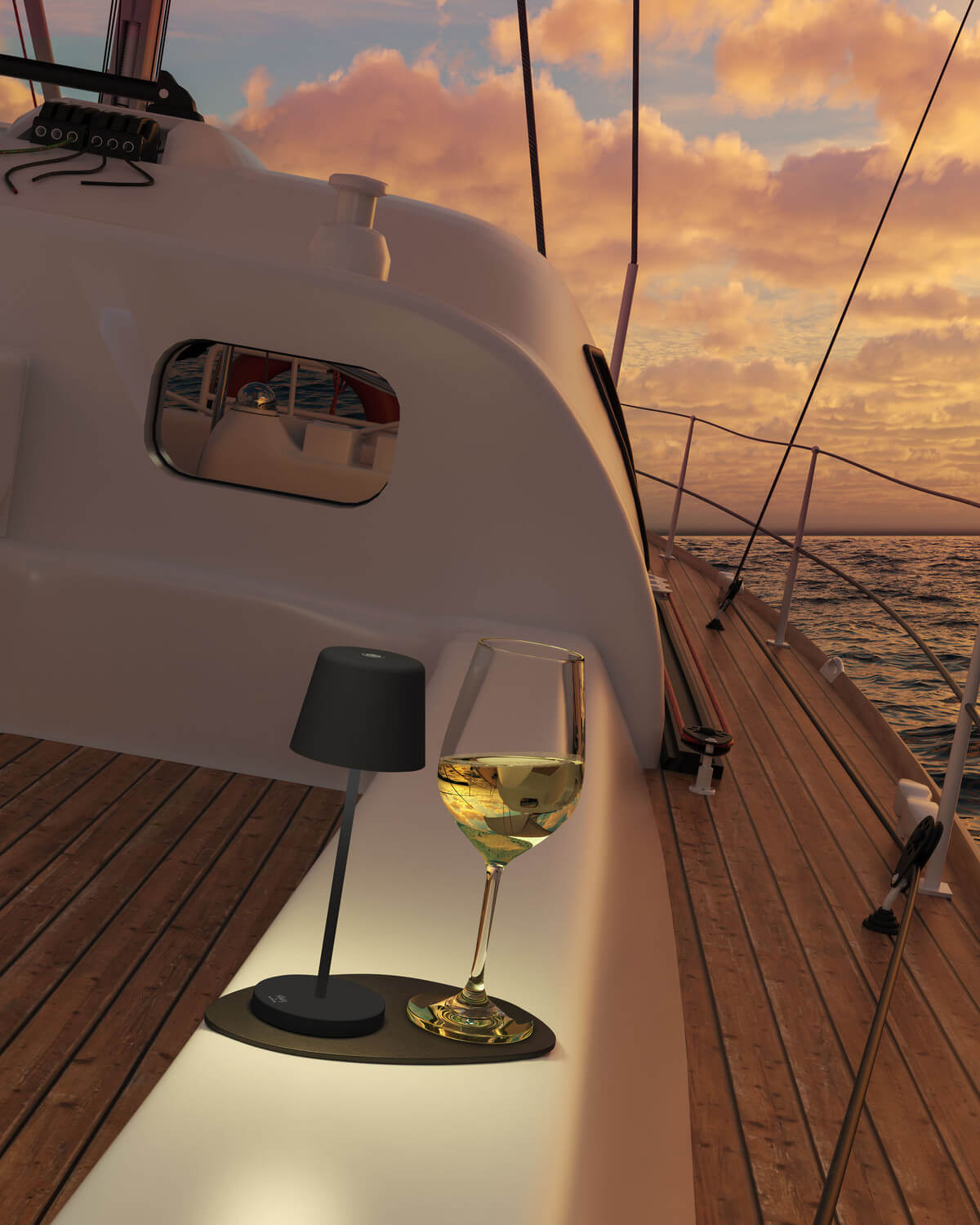 Ambiance de bord : verre de vin blanc et lampe posée sur un voilier au coucher du soleil