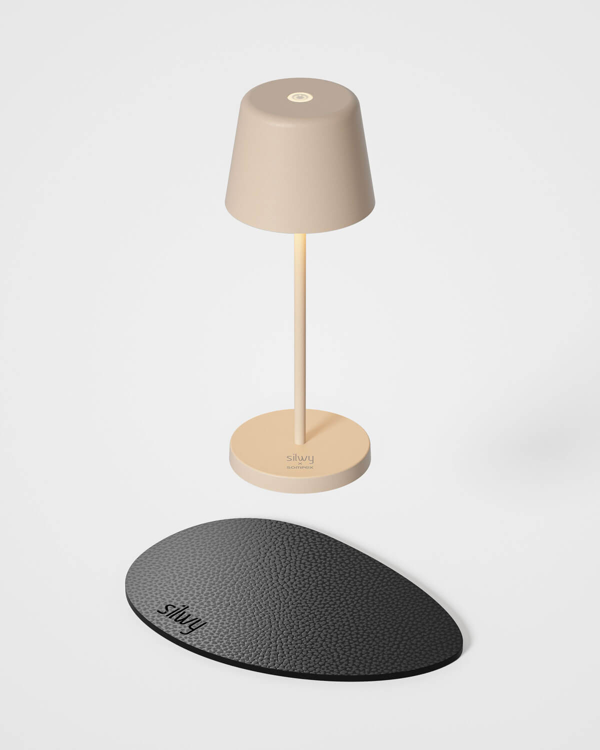 Lampe sans fil beige avec son socle rond et son tapis antidérapant noir.