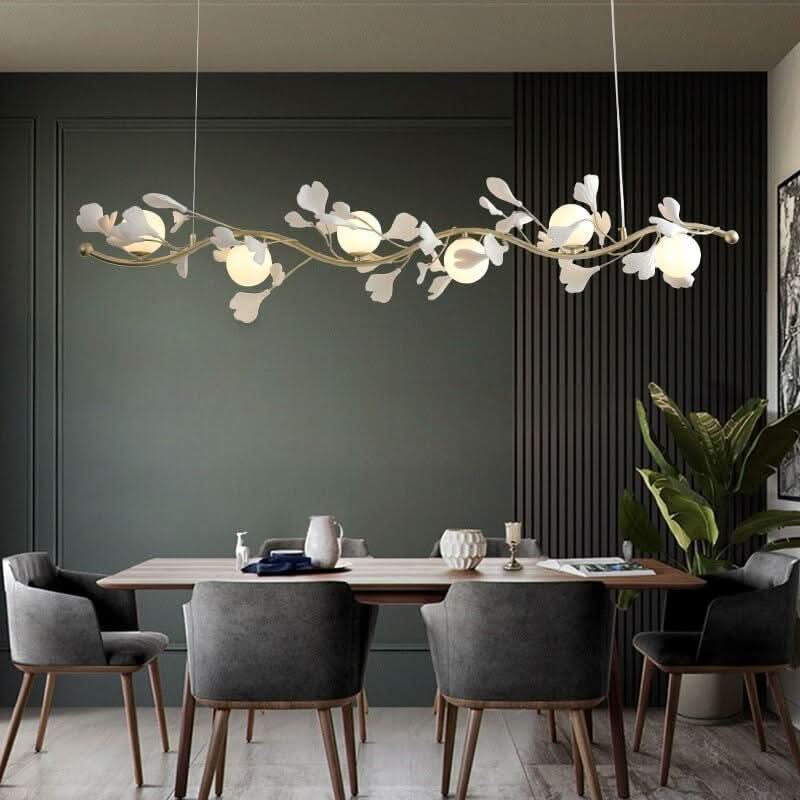 Suspension fleurs dorée au-dessus d'une table à manger dans une salle verte