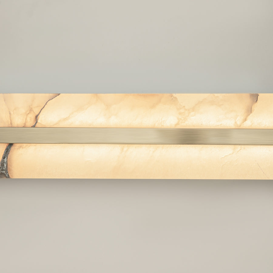 Gros plan sur la pierre veinée et la baguette métallique brossée en partie centrale