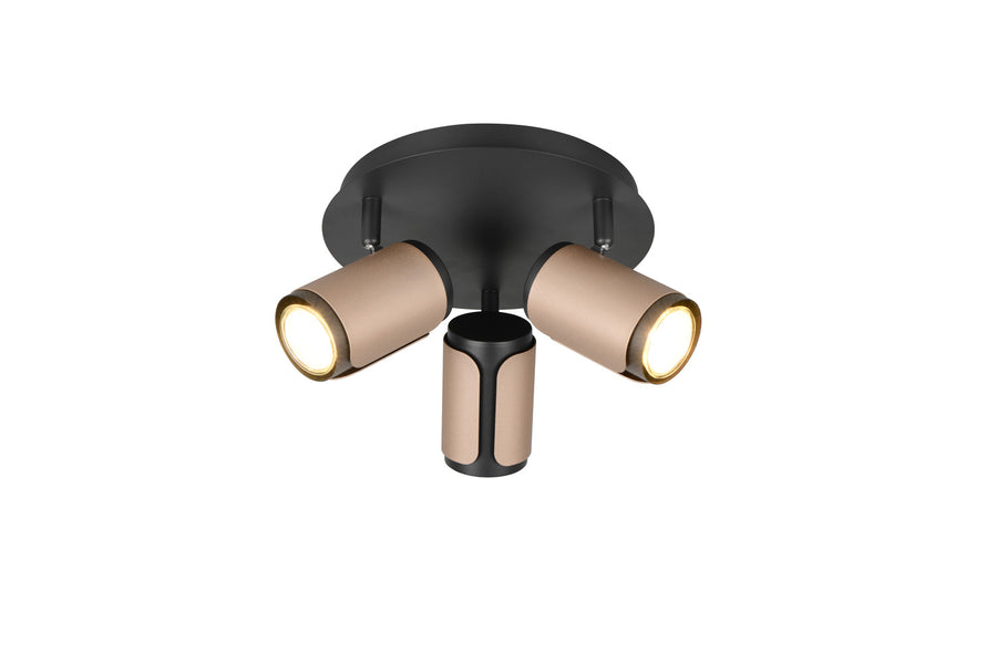 Spot plafonnier trois projecteurs cylindriques orientables beige et noir, allumé sur fond blanc.