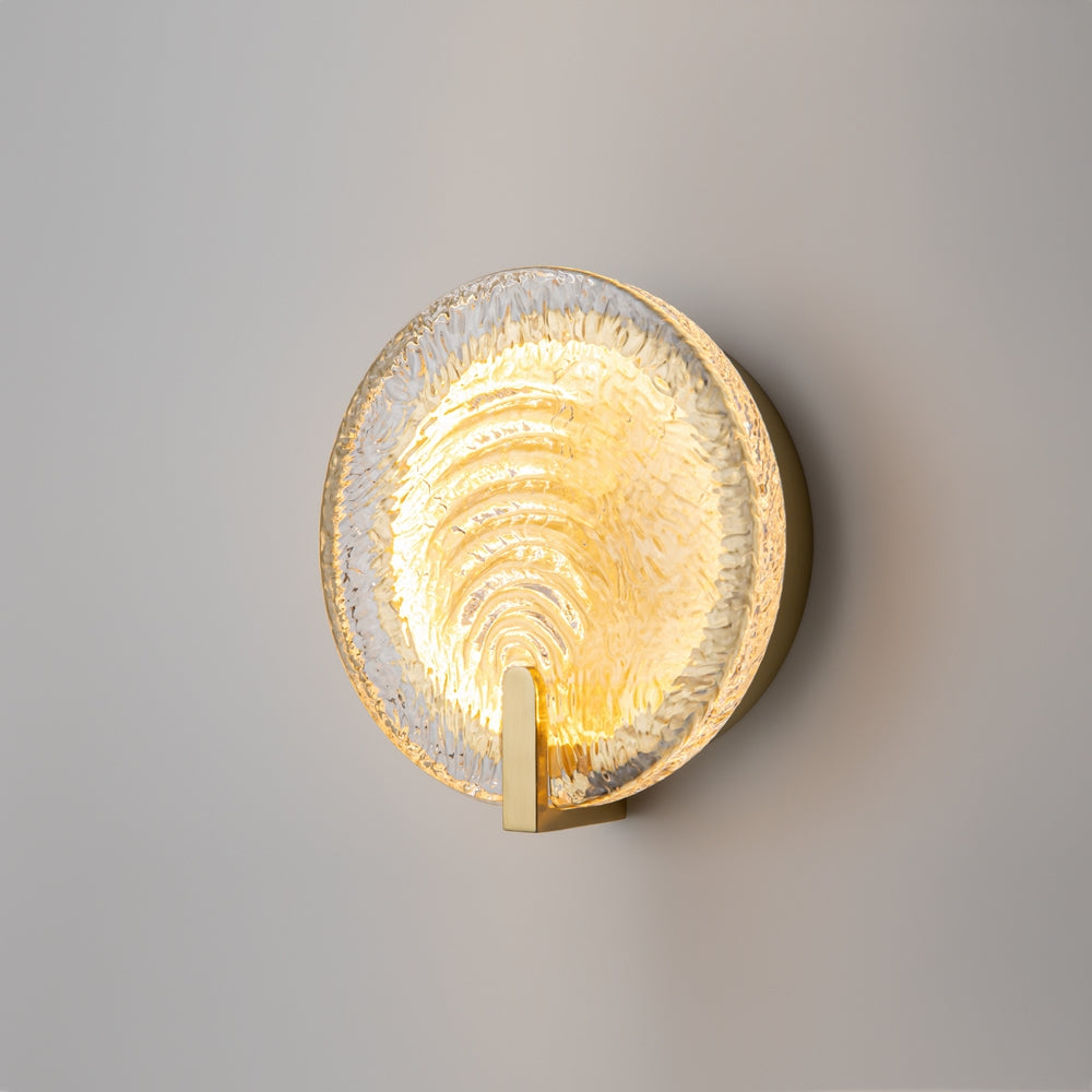 Applique murale allumée fixée sur un mur gris, halo de lumière dorée