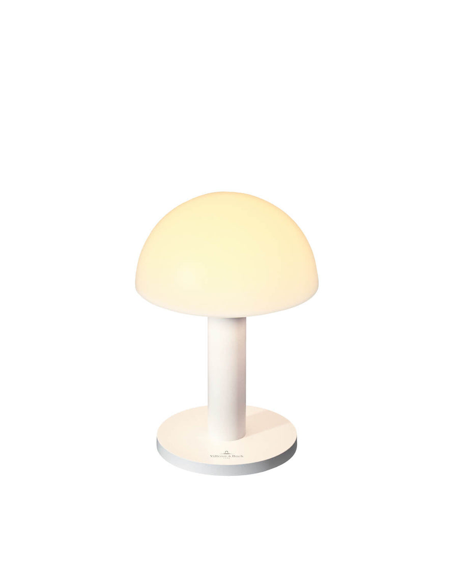 Lampe blanche de face sur fond blanc, abat-jour dôme éteint et pied cylindrique