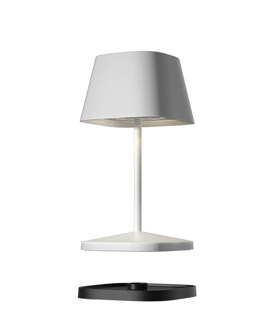 Vue éclatée du luminaire montrant l'abat-jour, le pied, le socle blanc et l'embase noire