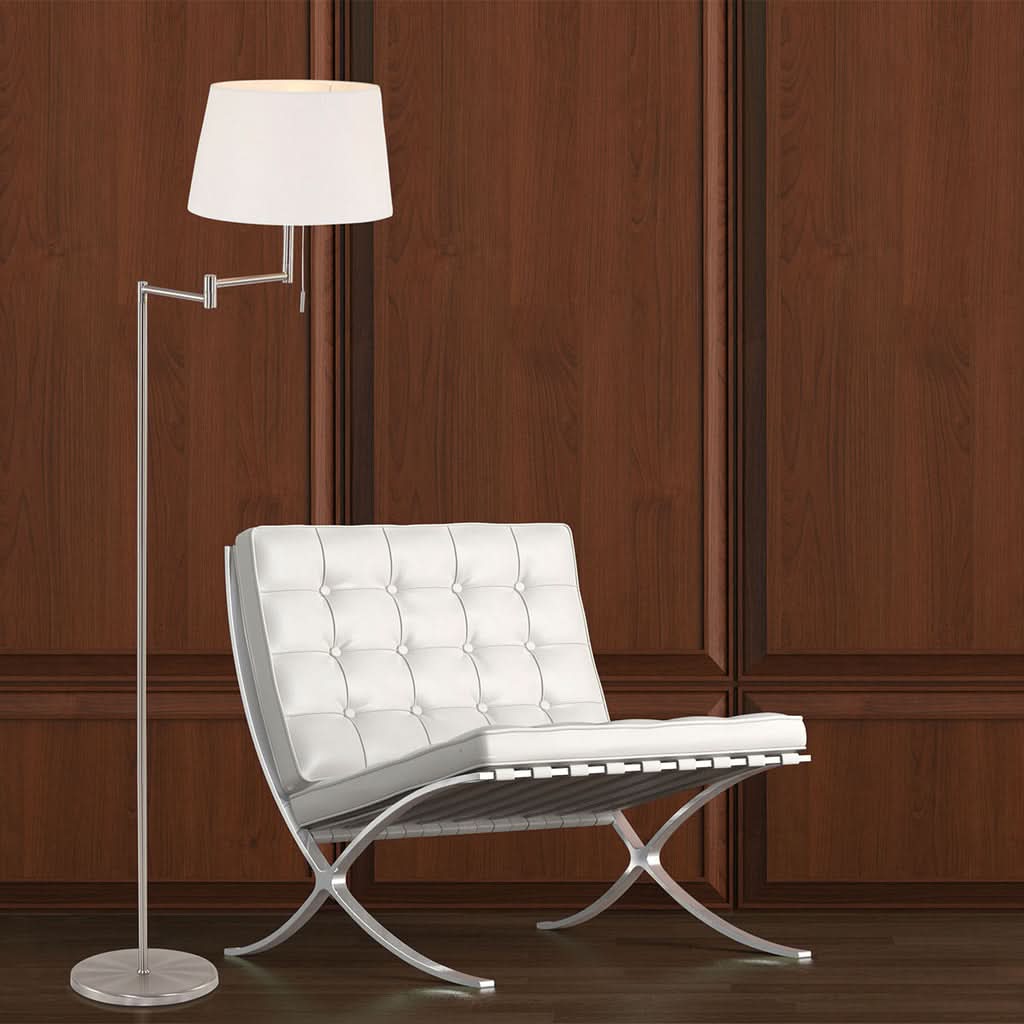 Mise en ambiance salon avec lampadaire allumé près d'un fauteuil blanc et mur bois.