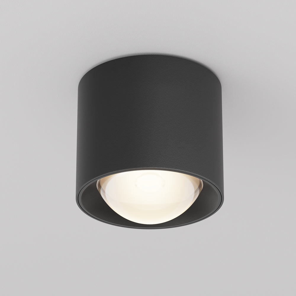 Plafonnier noir cylindrique fixe vu de face, diffuseur bombé allumé