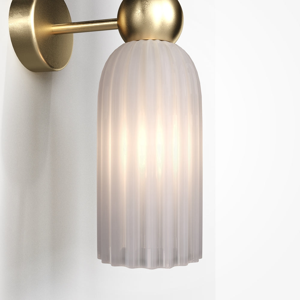 Détail de la finition : bras et sphère dorés, cylindre de verre strié allumé