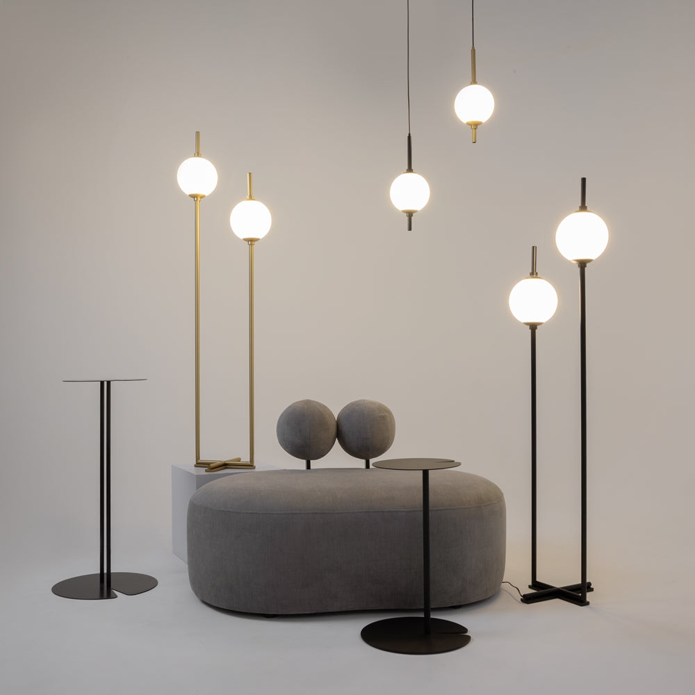 Mise en scène de plusieurs luminaires noirs et dorés dans un décor gris.